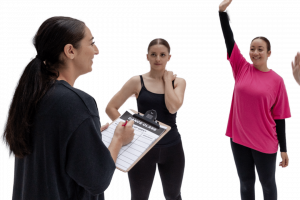 Dance teacher with her students taking smart syllabus notes